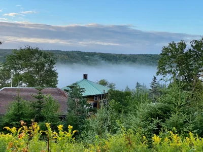 The image shows the roof of the main building at theTree of Life. The facility is seen rising above the boreal forest, with a view of the Salmonier River Valley at the head of St. Mary’s Bay, Newfoundland.